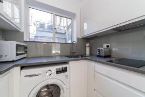 cocina con lavadora y microondas en Bright Studio Flat in the Heart of Marylebone en Londres