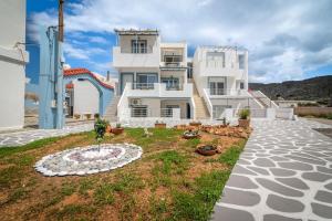 a large white house with a garden in front of it at Akali Apt Next to the Beach in Milatos