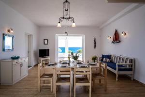 Golden View Villa with Private Swimming Pool في كريس أكتي: مطبخ وغرفة طعام مع طاولة وكراسي