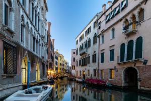 a canal in a city with buildings and a boat at Residence Ca' Foscolo in Venice