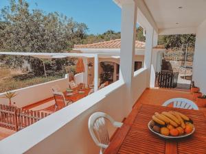 a bowl of fruit on a wooden table on a balcony at Green Ville in Faro