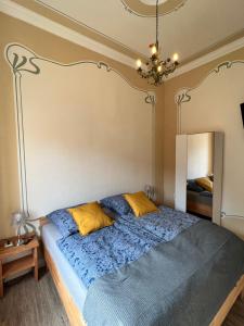 a bedroom with a bed with blue sheets and yellow pillows at Alte Post Sondershausen in Sondershausen