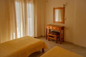 a room with a bed and a desk and a mirror at Ανεμώνη Apartments in Gialiskari