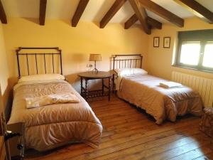 1 dormitorio con 2 camas, mesa y ventana en La Cirujana de Gredos, en San Esteban del Valle