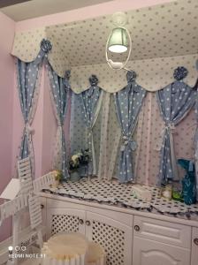 a room with a crib with blue and white curtains at 【遇見婚紗秘境】夜市4人包館、百萬影院KTV、Xbox、按摩浴缸/椅、真空管、好友同樂會 in Luodong