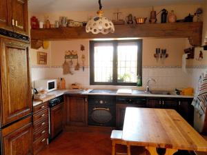 cocina con armarios de madera y mesa de madera en La Cirujana de Gredos, en San Esteban del Valle