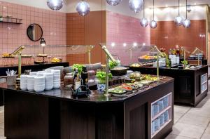 un buffet en un restaurante con comida en una barra en Vienna House by Wyndham Diplomat Prague, en Praga