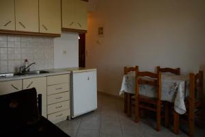 a kitchen with a table and a sink and a table and chairs at Ανεμώνη Apartments in Gialiskari