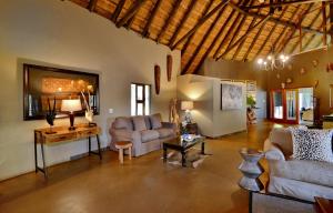 ein Wohnzimmer mit 2 Sofas und einem Tisch in der Unterkunft Black Rhino Game Lodge in Pilanesberg
