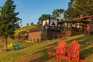 two red chairs sitting in front of a house at Sierra Garden Houses in Bom Jardim da Serra