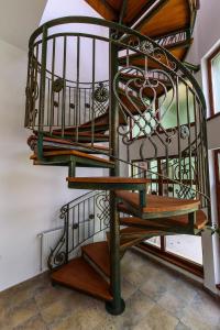 a wooden spiral staircase with a green and wooden railing at Interbelic vibe in Cluj-Napoca