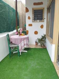 a patio with a table and green grass at Fay's House in Mesargos