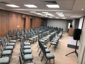 a conference room with chairs and a podium in it at Diaudi Hotel in São José