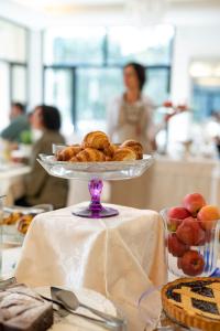 a plate of croissants and apples on a table at Hotel Baby B&B in Milano Marittima