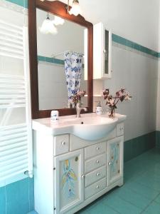 W łazience znajduje się umywalka i lustro. w obiekcie B&B Il Giardinetto Alghero w mieście Alghero