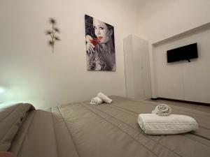 1 dormitorio con 1 cama y una pintura en la pared en CconfortHotels Appartamento Crispi - SELF CHECK IN en Bari