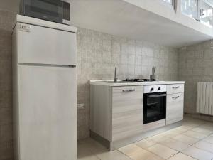 a kitchen with a white refrigerator and a stove at CconfortHotels Appartamento Crispi - SELF CHECK IN in Bari