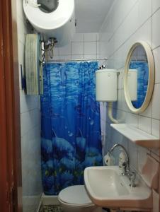 baño con cortina de ducha azul y lavamanos en Fay's House, en Mesagrós