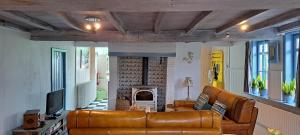 a living room with a leather couch and a fireplace at 't Haringehuys in Poperinge