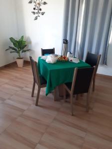 - une table à manger avec une table et des chaises vertes dans l'établissement Hotel Marquês de Maricá, à Maricá