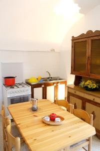 a kitchen with a wooden table and a stove at Masseria Curatori in Monopoli