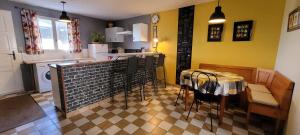 a kitchen with a table and a kitchen with yellow walls at Entre Ciel et Marais in Graignes