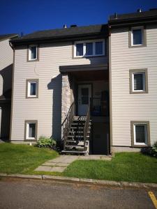 a house with a staircase leading to the front door at Le 4 SAISONS 2 in Beaupré