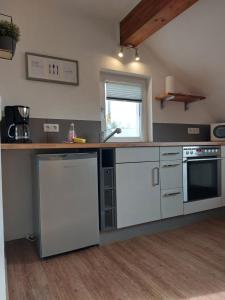 a kitchen with white appliances and a counter top at Ferienwohnung Kohl'sche Hof in Juhöhe