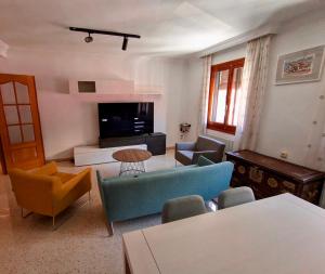 a living room with a couch and chairs and a tv at Charming Home in Lorca Murcia in Lorca