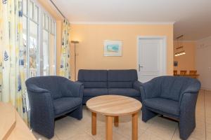 ein Wohnzimmer mit einer Couch und zwei Stühlen und einem Tisch in der Unterkunft Dünenschloss Dünenschloss 2-09 in Kühlungsborn