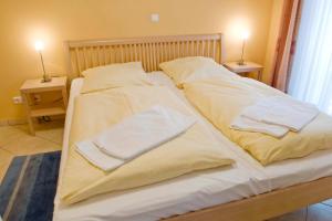 ein Bett mit weißen Laken und Handtüchern darauf in der Unterkunft Dünenschloss Dünenschloss 2-09 in Kühlungsborn + 7 Fotos