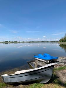 two boats sitting on the shore of a lake at Agroturystyka Widokówka Nielisz in Nielisz