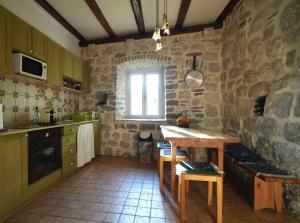 a kitchen with a wooden table and a window at Apartment Dyonis Perast in Perast