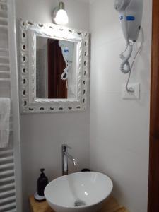 La salle de bains est pourvue d'un lavabo et d'un miroir. dans l'établissement dalla CARLA in Toscana, à Monte San Savino