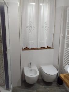 a white bathroom with a toilet and a sink at dalla CARLA in Toscana in Monte San Savino +8 photos