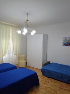 - une chambre avec 2 lits bleus et un lustre dans l'établissement dalla CARLA in Toscana, à Monte San Savino