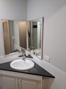 a bathroom with a sink and two mirrors at Bunbury's Most Convenient Location in Bunbury