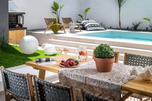 a table with fruit on it next to a pool at Assos Aqua Apartment in Heraklio Town