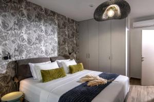 a bedroom with a large white bed with green pillows at Assos Aqua Apartment in Heraklio Town +9 photos