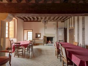 una sala da pranzo con tavoli, sedie e camino di 17th century manor house in the Niavre a Moussy