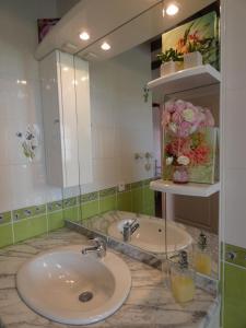 ein Badezimmer mit einem Waschbecken und einem großen Spiegel in der Unterkunft Les Logis du Breuil in Marchéville