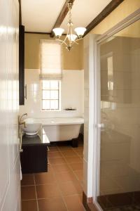 a bathroom with a tub and a sink at Remhoogte Mountain Lodge in Jacksonstuin