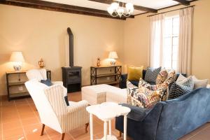 a living room with a couch and chairs and a stove at Remhoogte Mountain Lodge in Jacksonstuin
