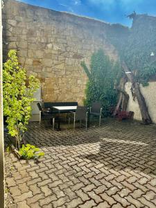a patio with a table and chairs and a stone wall at Ferienhaus Stadtmauer in Lichtenfels