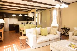 a living room with a white couch and a kitchen at Remhoogte Mountain Lodge in Jacksonstuin