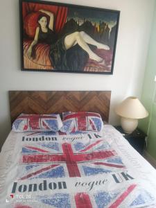 a bedroom with a bed with a painting on the wall at sur ile du pollet in Dieppe