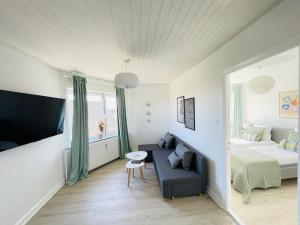 Habitación pequeña con cama, sofá y cama en aday - Greenway 2 bedrooms apartment, en Frederikshavn