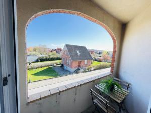 une fenêtre voûtée avec une maison en arrière-plan dans l'établissement aday - Greenway 2 bedrooms apartment, à Frederikshavn