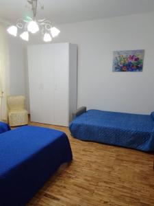 1 dormitorio con 2 camas azules y 1 silla en dalla CARLA in Toscana en Monte San Savino
