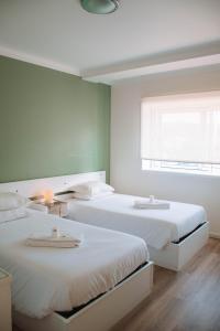 1 dormitorio con 2 camas y ventana en Arca Nova Guest House & Hostel Caminha, en Caminha